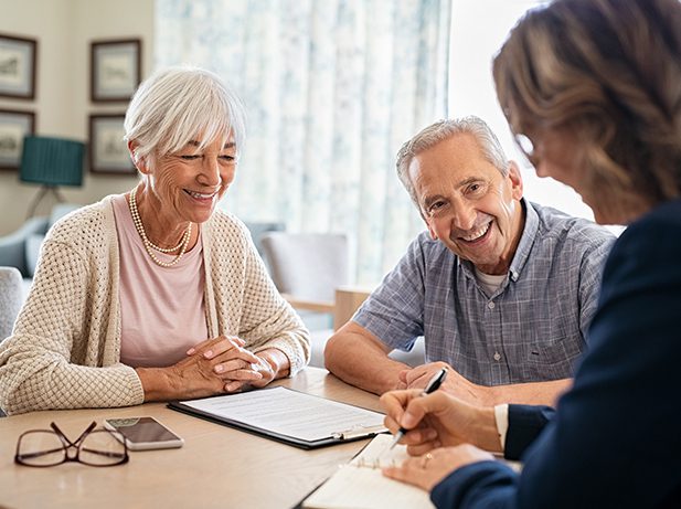 Senior couple reviewing documents with advisor.