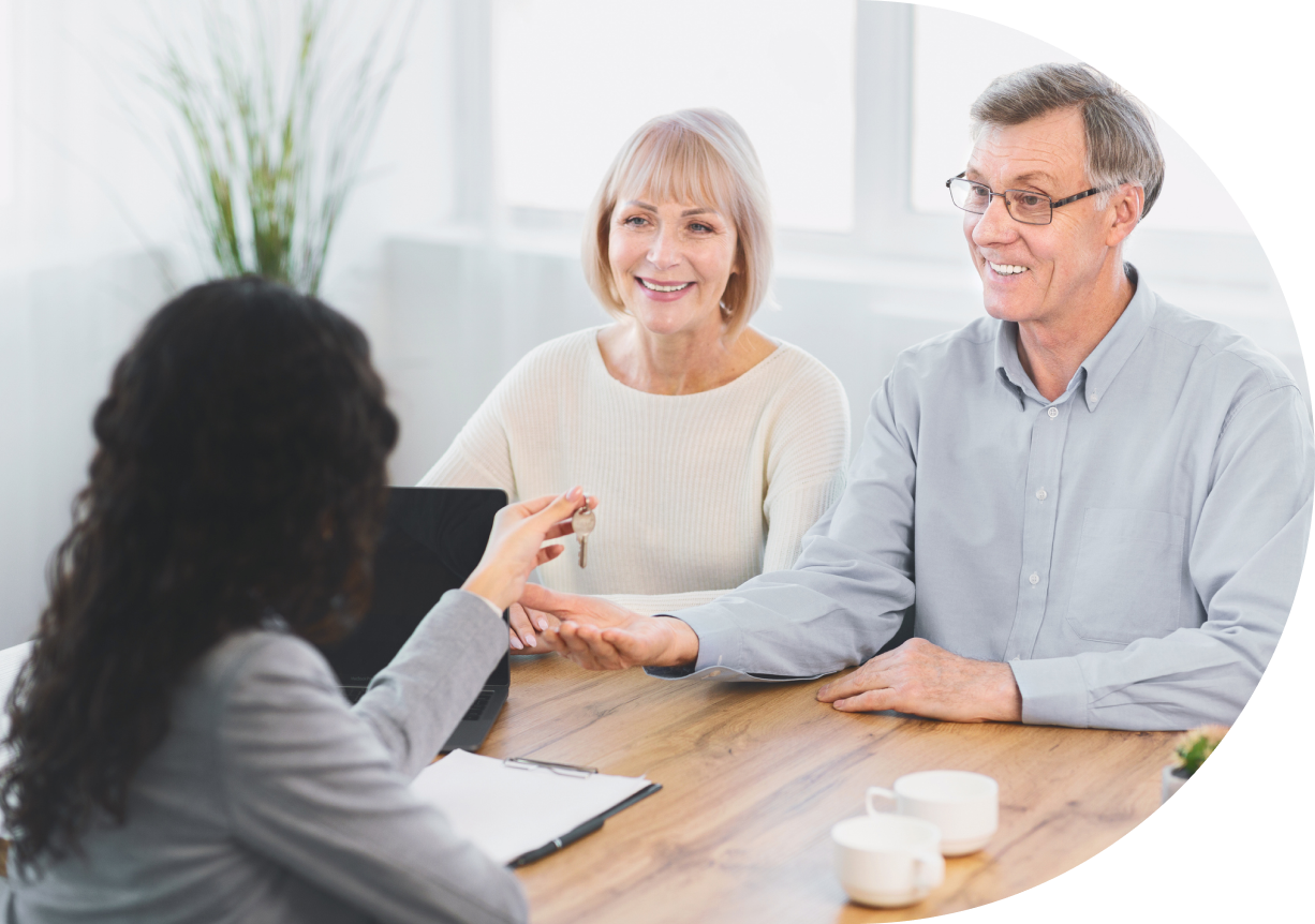 Senior couple receiving house keys from agent.