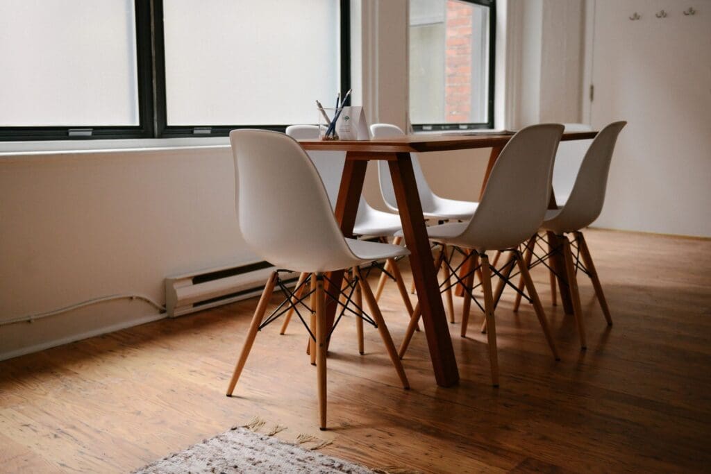 A table and chairs in front of a window.