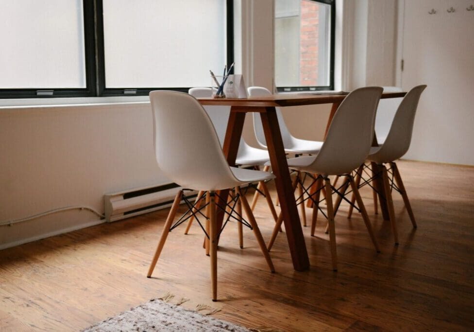 A table and chairs in front of a window.